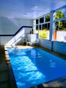 a large blue swimming pool with a staircase at Pousada Luar da Serra in Valença