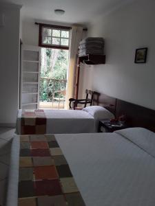 a bedroom with two beds and a window at Pousada Luar da Serra in Valença +24 photos