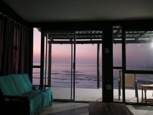 a bedroom with a view of the ocean at The Laughing Mermaid in Coffee Bay