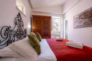 a bedroom with a large bed with a red blanket at Ortigia Green in Syracuse