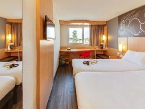 a hotel room with two beds and a desk at ibis Montpellier Sud in Montpellier +108 photos