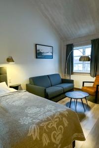 a bedroom with a bed and a couch and a table at Vogafjós Farm Resort in Myvatn