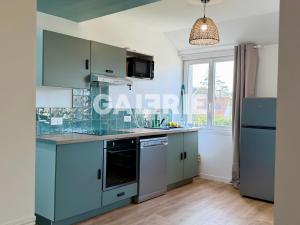 a kitchen with blue cabinets and a window at GC - Les Oyats in Wissant