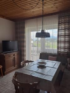 a dining room with a table and a television at Haus Bärnthaler in Faak am See