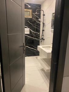a bathroom with a door open to a bathroom with a sink at Bissan Condimenium in Amman +31 photos