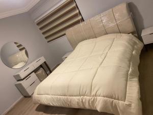 a bedroom with a white bed and a mirror at Bissan Condimenium in Amman