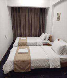 a hotel room with two beds and a couch at NJ Teachers Hotel in Luxor