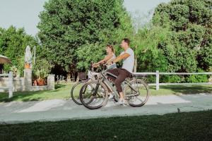 a man and woman riding a bike down a sidewalk at Masseria L'Uliveto Agri Resort in Otranto