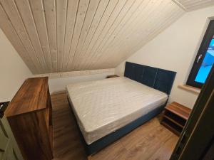 a small bedroom with a bed and a wooden floor at Letnisko nad jeziorem in Skulsk