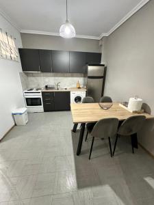a kitchen with a wooden table and chairs in it at GL House in Asprovalta