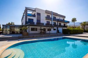 a house with a swimming pool in front of a building at Suya Boutique Hotel in Kyrenia