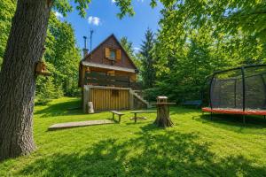 a park with a house and a playground at Chatka Kačka in Jedovnice +4 photos