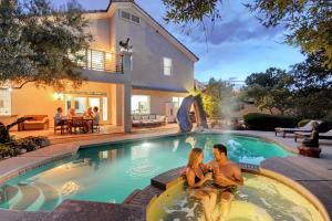 a man and a woman sitting in a swimming pool at Summerlin Private Buddha Estate Resort - Pool, Spa, Sauna, Game Room, Basket ball, Mini golf, Gym in Las Vegas