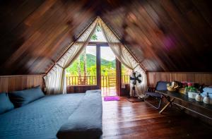 a bedroom with a bed in a room with a window at Leaf Village & Farm Làng Lá in Danang