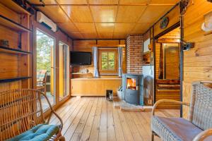 a living room with a fireplace in a log cabin at Chatka Kačka in Jedovnice