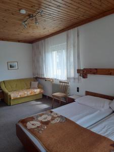 a hotel room with two beds and a couch at Haus Bärnthaler in Faak am See
