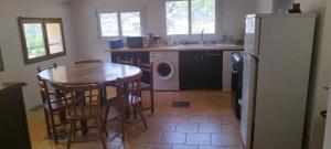 a kitchen with a table and a washer and dryer at Le Mazet in Nohèdes