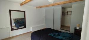 a bedroom with a bed and a mirror at Le Mazet in Nohèdes