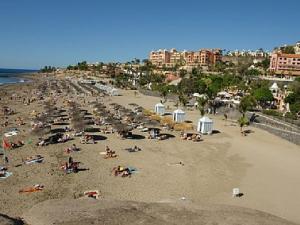 una multitud de personas en una playa con edificios en Casa Berta, en Adeje