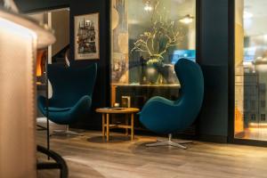 two blue chairs and a table in a room at Motel One Copenhagen in Copenhagen +50 photos