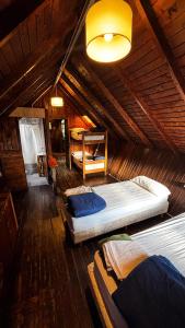 a bedroom with two beds in a wooden house at Alaska Patagonia Hostel in San Carlos de Bariloche