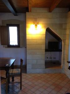 een woonkamer met een stenen muur en een televisie bij Le 3 tartarughe in Lascari