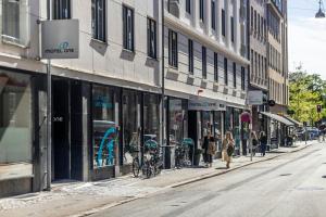 a group of people walking down a street with stores at Motel One Copenhagen in Copenhagen