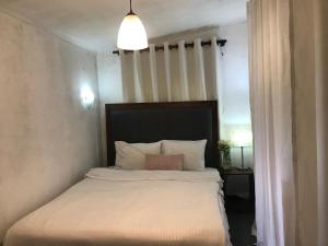 a bedroom with a bed with white sheets and pillows at Fair Field Bungalow in Nuwara Eliya