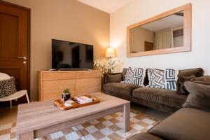 a living room with a couch and a tv at Luxury Ocean View Apartment, Private Beach, Infinity Pool, near Jan Thiel C4 in Willemstad