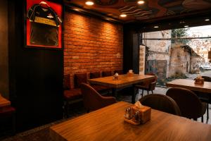 a restaurant with tables and chairs and a brick wall at Checkpoint KTM - Boutique Urban Hostel in Kathmandu