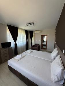 a bedroom with a large white bed in a room at Yuliya Guest House in Sapareva Banya