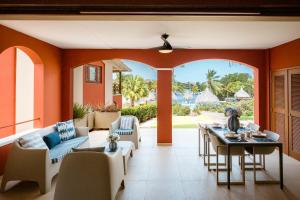 an open living room with a table and chairs at Luxury Ocean View Apartment, Private Beach, Infinity Pool, near Jan Thiel C4 in Willemstad