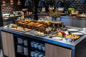a breakfast buffet with bread and other food on a counter at Motel One Copenhagen in Copenhagen