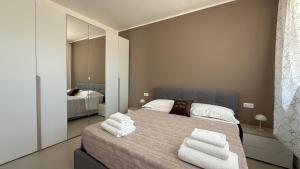 a bedroom with a large bed with towels on it at Soffio del Mar in Pila