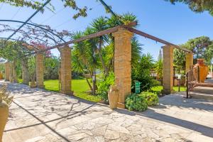 a garden with a brick archway and plants at Masseria L'Uliveto Agri Resort in Otranto