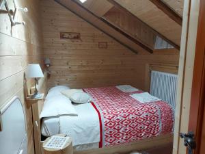 a small bedroom with a bed in a wooden cabin at B&B ABETE BIANCO in Auronzo di Cadore