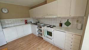 a kitchen with white appliances and a clock on the wall at Gårdsjö 5 in Gårdsjö