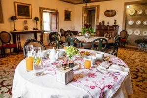 a dining room with two tables with food and orange juice at Casa De Anquiao - Turismo de Habitação in Ponte de Lima