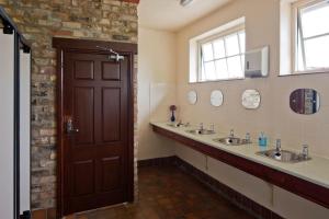 a bathroom with two sinks and a brown door at Mill Farm Shepherds Hut in Great Driffield +17 photos