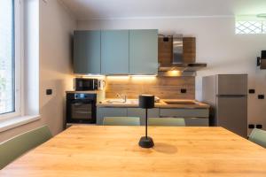 eine Küche mit einem Holztisch und Stühlen sowie eine Küche mit einer Theke in der Unterkunft Casa Luccon in Salionze + 7 Fotos