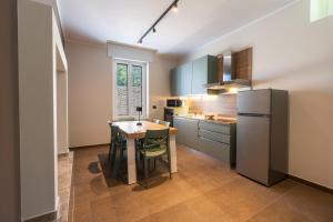 eine Küche mit einem Tisch und einem Kühlschrank in der Unterkunft Casa Luccon in Salionze