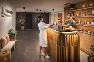 a man and a woman standing at a counter in a kitchen at Kamengrad Hotel & SPA in Panagyurishte +160 photos