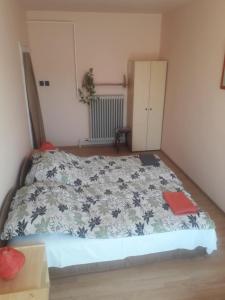 a bedroom with a bed with a blue and white blanket at Közös Nevező Vendegház in Keszthely