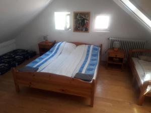 a bedroom with a bed and two tables and two windows at Közös Nevező Vendegház in Keszthely