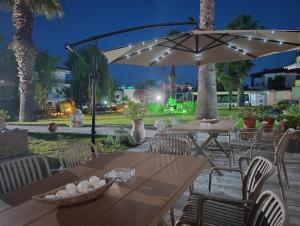 an outdoor patio with tables and an umbrella at Villa Christina Sea Side A in Hanioti