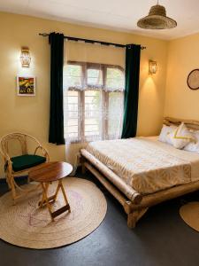 a bedroom with a bed and a chair and a window at Hakuna matata villas & hostels in Arusha