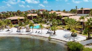 an aerial view of a resort with a pool and palm trees at Luxury Ocean View Apartment, Private Beach, Infinity Pool, near Jan Thiel C4 in Willemstad