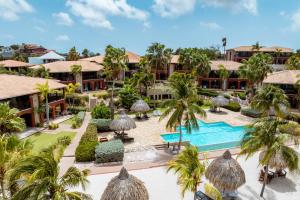 an aerial view of a resort with a pool and palm trees at Luxury Ocean View Apartment, Private Beach, Infinity Pool, near Jan Thiel C4 in Willemstad