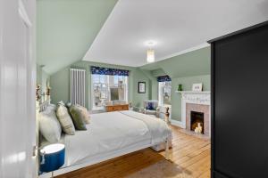 a bedroom with a white bed and a fireplace at Hermitage Suite - Stylish Shared Accommodation in Dundee