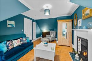 a blue living room with a couch and a fireplace at Hermitage Suite - Stylish Shared Accommodation in Dundee